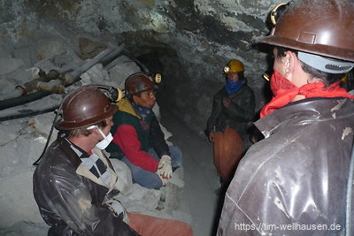 In einer kleinen Touristengruppe erläutert der Führer, wie auch heute noch Gestein abgebaut wird.