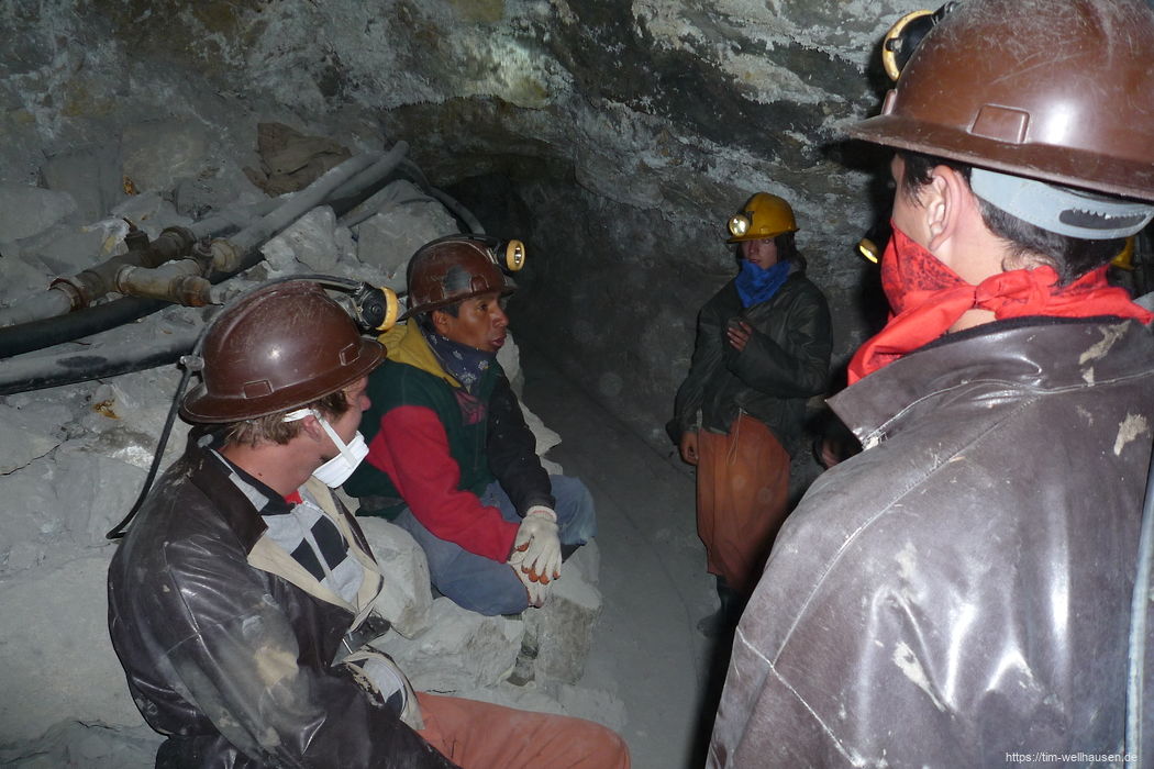 In einer kleinen Touristengruppe erläutert der Führer, wie auch heute noch Gestein abgebaut wird.